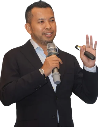Mohd Atasha speaking, holding a microphone, mid-gesture